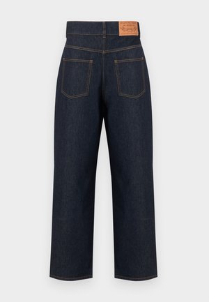 Jean droit bleu foncé avec étiquette patch à l'arrière et deux poches arrière avec surpiqûres orange.