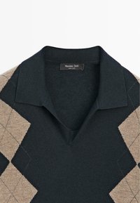 Donkergroene gebreide polotrui met beige accent van een ruitpatroon, voorzien van een V-hals en standaard kraag. Label vermeldt "Massimo Dutti."