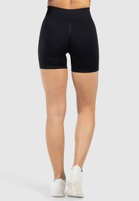 Zwarte sportshorts met een hoge tailleband, voorzien van een gladde textuur en een aansluitende pasvorm, ontworpen voor comfort en prestaties.