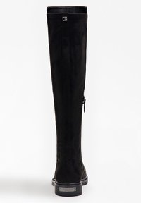 Mustat ylipolvensaappaat, jotka on valmistettu sametista. Tyylikäs muotoilu, jossa on sivuvetoketju ja logokoriste takana. Vankka pohja, jossa on kiiltävä viimeistely.