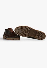 Zapatos de cuero marrón con cordones naranjas, con una suela texturizada y un dibujo rugoso para una mejor agarre. Diseñados con un estilo elegante y una silueta casual.