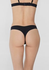 Czarny dół bikini o minimalistsycznym designie, gładkiej fakturze i niskim kroju, z bezszwowym paskiem i pełnym pokryciem z tyłu.