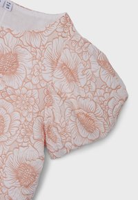 Blusa de un rosa claro con un patrón floral en rosa más oscuro. Presenta mangas abullonadas y una tela texturizada, que muestra intrincados diseños de flores.