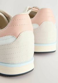 Baskets avec un dessus en cuir synthétique rose, des accents en daim crème, du mesh blanc, des détails cousus et des semelles en caoutchouc bleu clair.