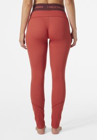 leggings de entrenamiento rojas con un patrón texturizado, que cuentan con una cinturilla ancha y detalles en panel contrastante en los tobillos.