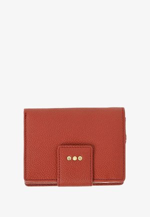 Porte-monnaie compact en cuir rouge avec une surface texturée, fermé par un rabat orné de trois petites clous en laiton ronds.