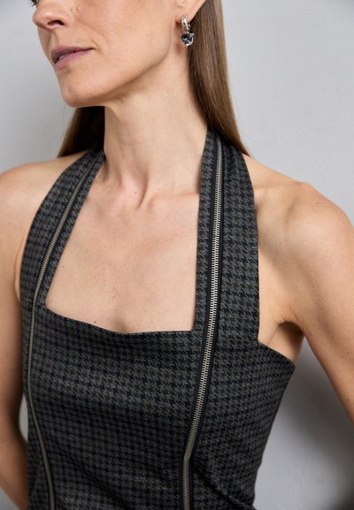 Zwart en grijs houndstooth haltertop met een vierkante halslijn, voorzien van een zichtbare ritssluiting aan de zijkant. Gladde textuur van de stof.