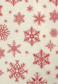 Rode sneeuwvlokpatronen op een crèmekleurige achtergrond, met verschillende geometrische ontwerpen en details, gedrukt op een gladde, zachte stof.