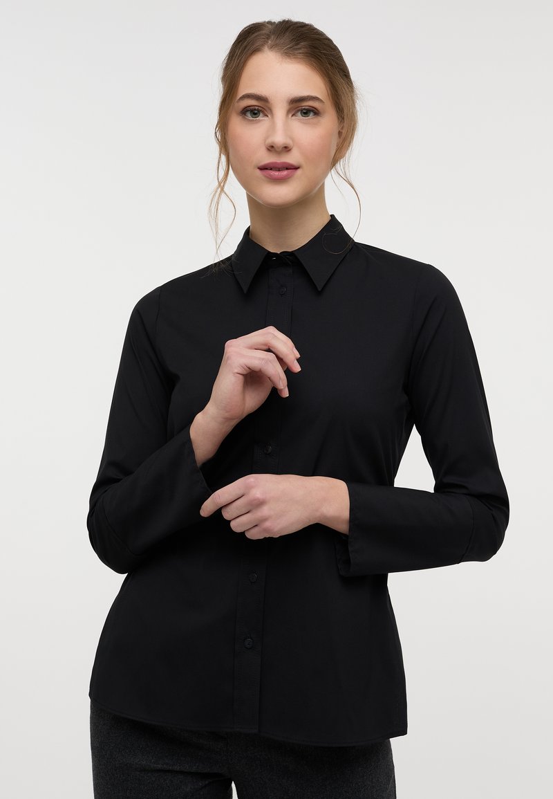 Black long-sleeve button-up shirt with a pointed collar, featuring a smooth texture and a tailored fit, designed for a modern look.