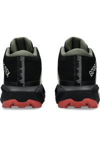 Czarne i zielone wodoodporne buty górskie z teksturowaną cholewką, odblaskowymi akcentami oraz czerwoną gumową podeszwą z przyczepnym wzorem bieżnika.