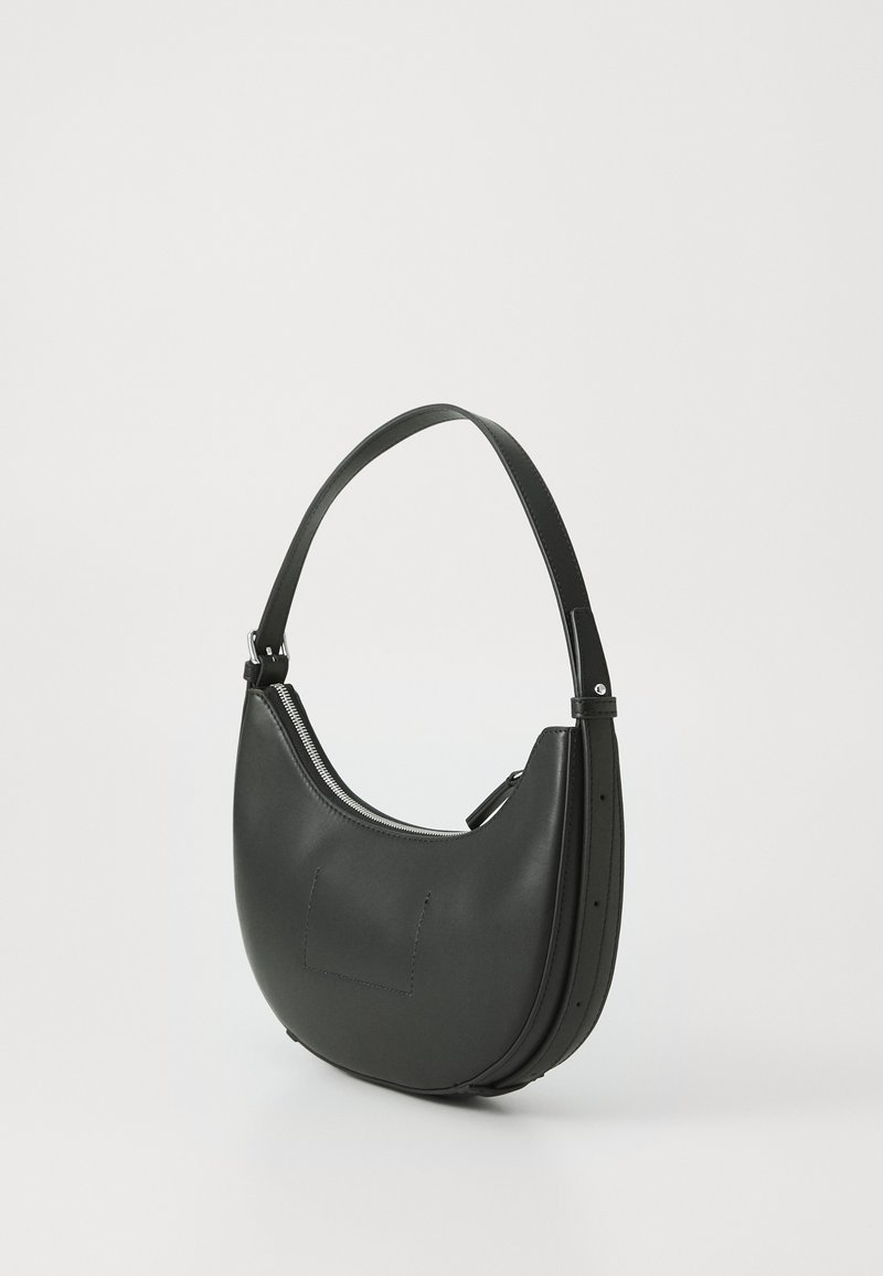 Czarna skórzana torebka o zakrzywionym kształcie, z zamkiem błyskawicznym i regulowanym paskiem na ramię. Gładka tekstura i minimalistyczny design.