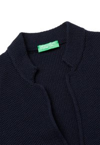 Marineblauer Strickcardigan mit strukturiertem Muster, Stehkragen und einem grünen Etikett mit der Aufschrift "United Colors of Benetton."