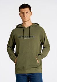 Sudadera verde de material suave, con un bolsillo tipo canguro en la parte frontal, capucha ajustable con cordón y texto impreso "COPENHAGUE LUNDBERG" en color marino.