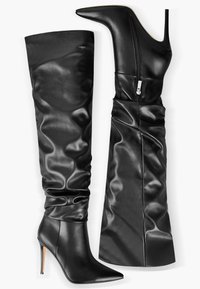 Bottes en cuir noires montant jusqu'aux genoux avec des bouts pointus, des talons aiguilles et des fermetures éclair latérales, présentées de face et de profil.