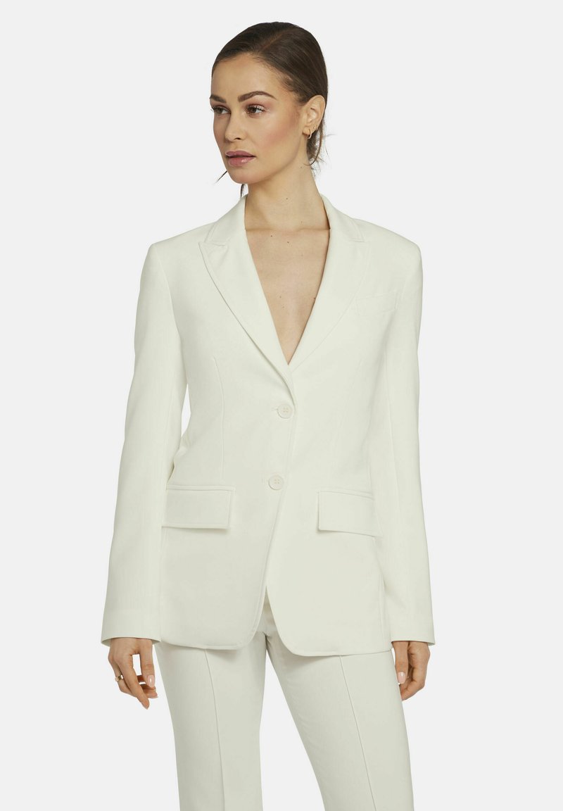 Witte op maat gemaakte blazer met een diepe V-hals, sluiting met twee knopen en voorzakken. Soepele textuur en gestructureerde pasvorm.