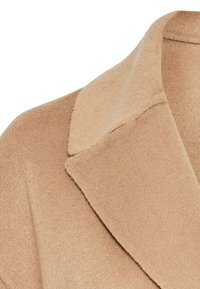 Abrigo de mezcla de lana beige con una textura suave, que presenta un cuello de solapa ancho y líneas limpias, centrado en la calidez y la simplicidad.