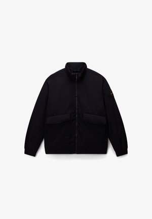 Chaqueta negra con cremallera, cuello alto, dos bolsillos delanteros tipo parche, puños elásticos y un detalle de logotipo en la manga. Textura de tela suave.