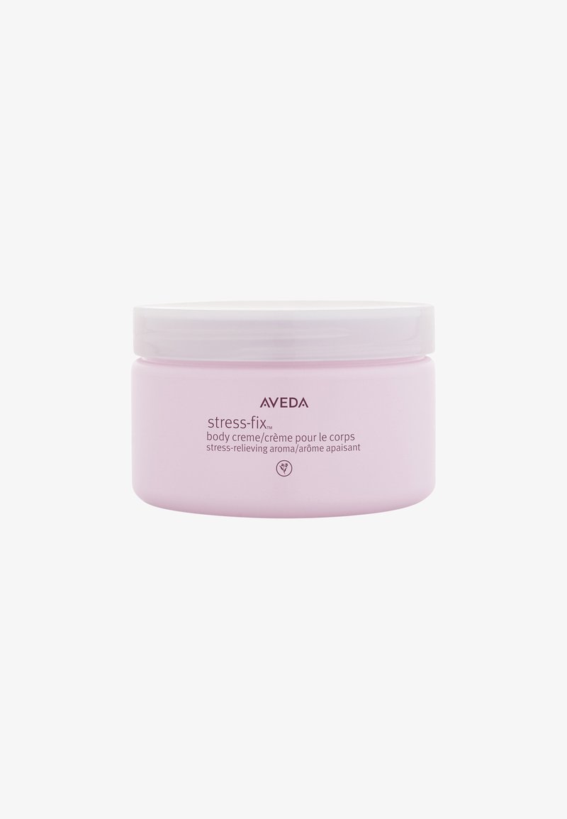 Crème corporelle Aveda Stress-Fix dans un pot rond en plastique rose avec un couvercle blanc. L'étiquette présente le nom du produit et une description bilingue en texte clair.