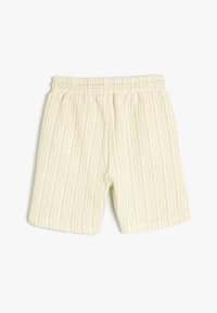Helle beige Shorts mit vertikalen Streifen, aus strukturiertem Gewebe gefertigt. Verfügt über einen elastischen Bund und eine lockere Passform. Keine sichtbaren Taschen.