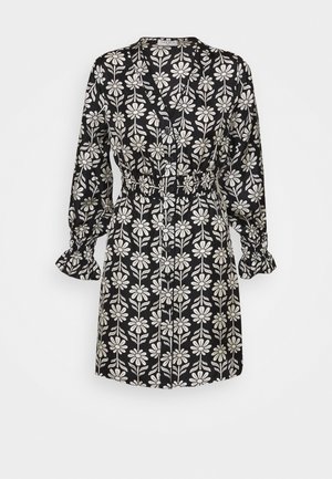 Schwarzes Kleid mit einem floralen Muster in Weiß. Es hat lange Ärmel mit Rüschensaum, eine Knopfleiste vorne und einen elastischen Bund.