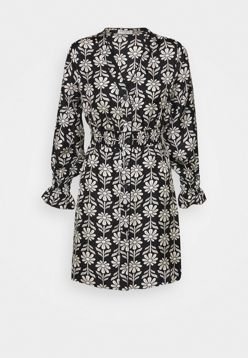 Czarna sukienka w kwiatowy wzór w białym kolorze. Posiada długie rękawy z falbanami przy mankietach, zapięcie na guziki oraz elastyczną talię.