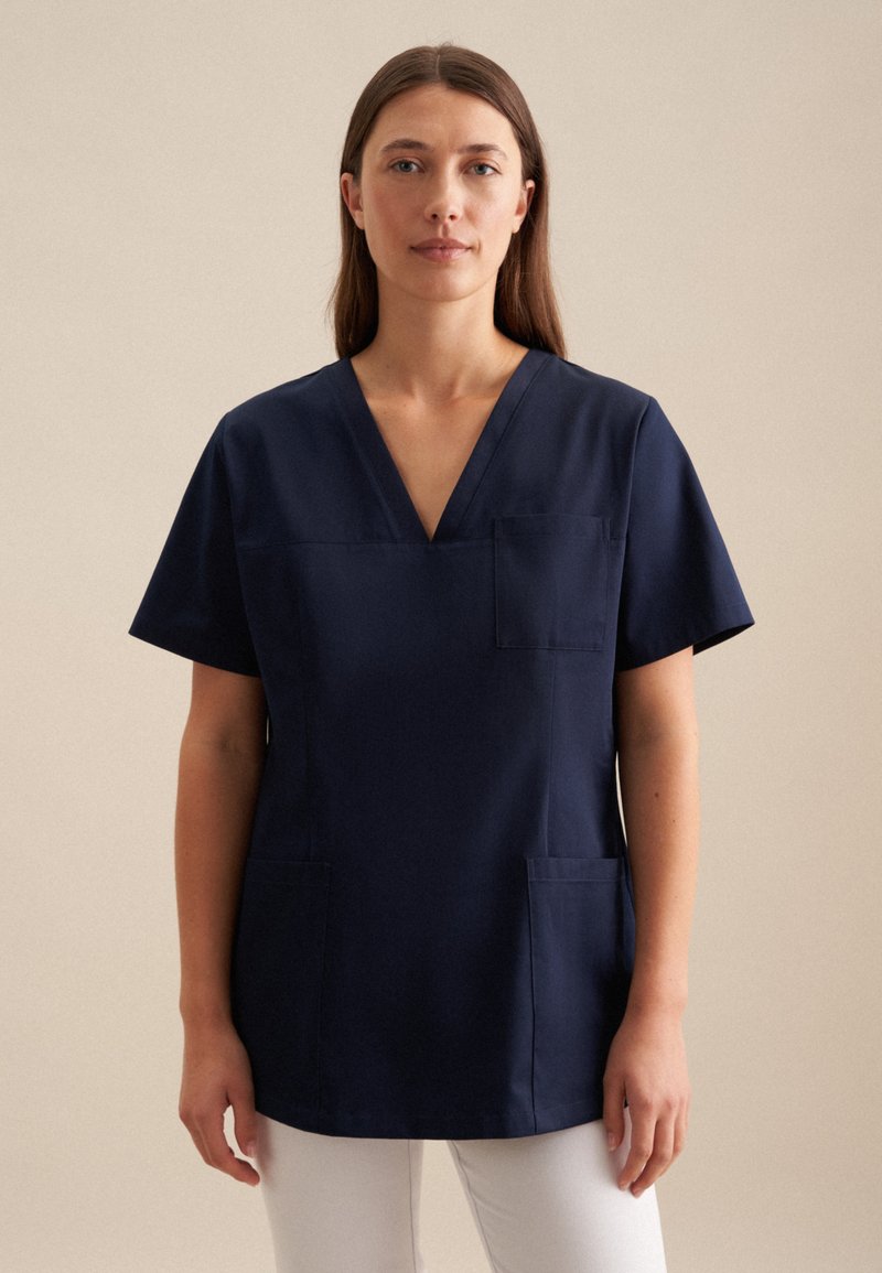 Maglietta da scrubs a maniche corte blu navy con scollatura a V, due tasche frontali e vestibilità comoda. Realizzata in tessuto resistente con una superficie liscia.