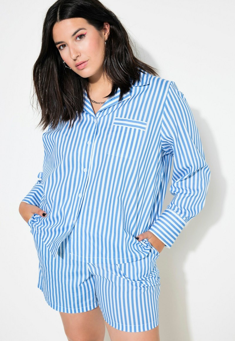 Conjunto de pijama a rayas azules y blancas que incluye una camisa de botones con un bolsillo y pantalones cortos. La tela tiene una textura suave y un corte relajado.
