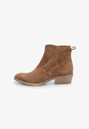 Bottine en suede marron avec un bout rond, un faible talon bloc, une languette à l'arrière et des panneaux élastiques sur les côtés pour un enfilage facile.