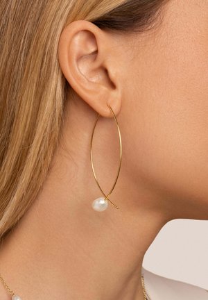 Pendiente de aro dorado con forma alargada, adornado con una perla blanca. Acabado metálico suave con un diseño minimalista.