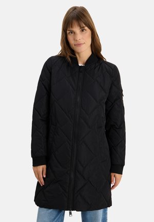 Veste noire matelassée avec fermeture éclair, poignets côtelés et design jusqu'aux genoux. Comprend des coutures diagonales et des poches latérales.