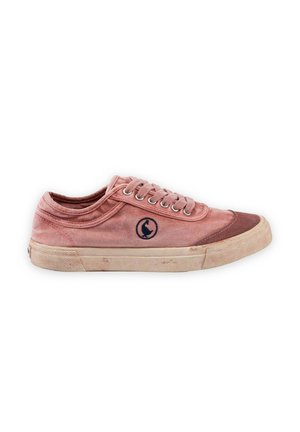 Zapatilla de lona rosa desgastada con suela blanca, logotipo circular negro en el lateral y puntera marrón, mostrada de perfil sobre fondo blanco.