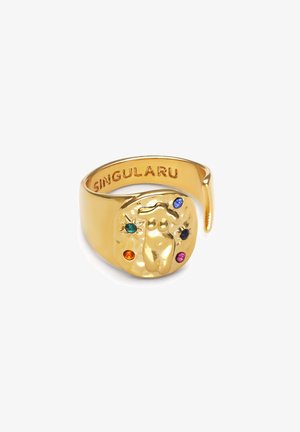 Złoty pierścionek z teksturowanym, abstrakcyjnym wzorem z centralną postacią i kolorowymi kamieniami szlachetnymi: zielonymi, niebieskimi, pomarańczowymi, czarnymi i różowymi akcentami.