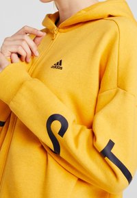 adidas Performance Felpa con zip - gold-coloured