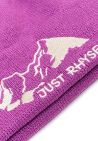 Beanie in maglia viola con una silhouette di montagna color crema e la scritta "JUST RHYSE" in ricamo bianco. Tessuto morbido e testurizzato.