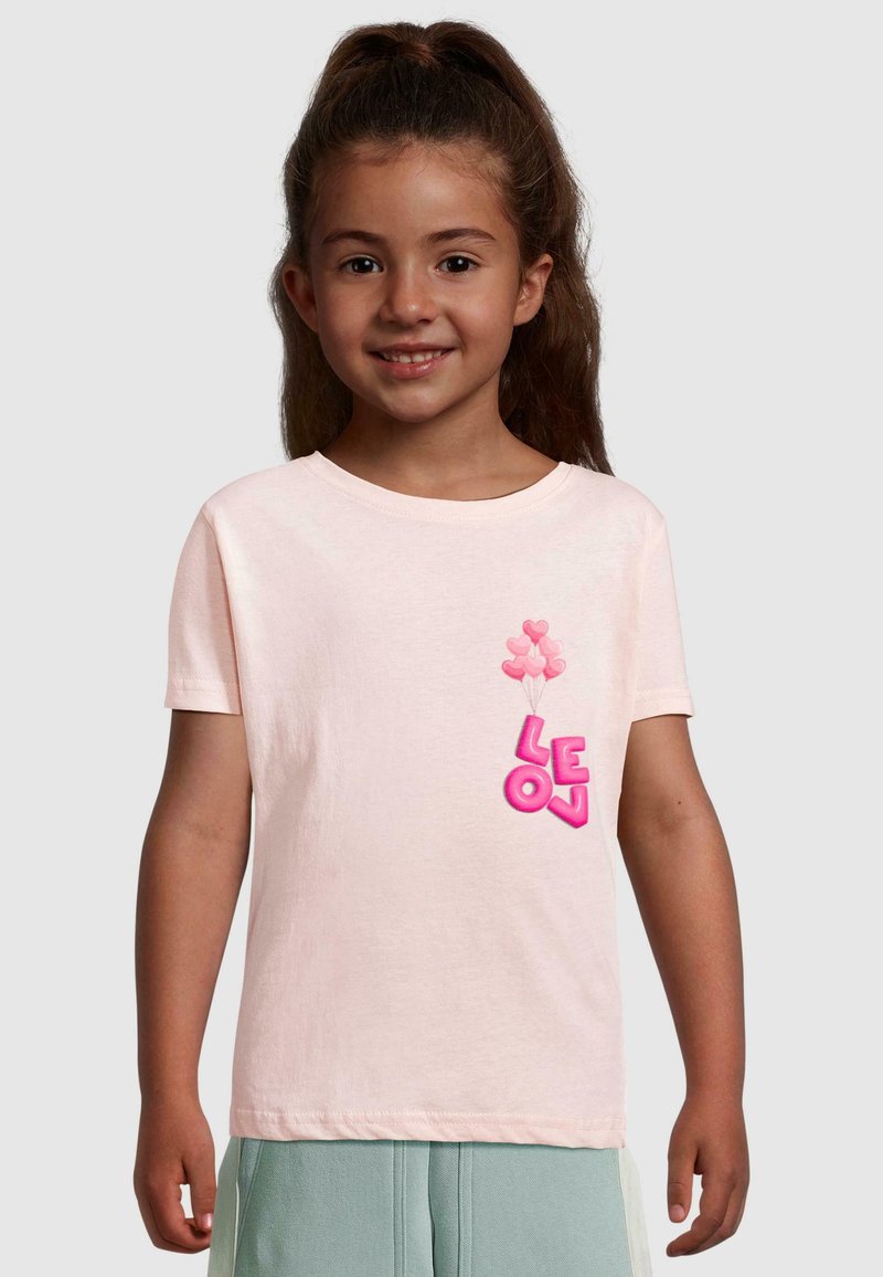 Lyserød kortærmet t-shirt med "LEON" i fede pink bogstaver og grafik af hjerteballoner på venstre side. Blødt bomuldsstof.