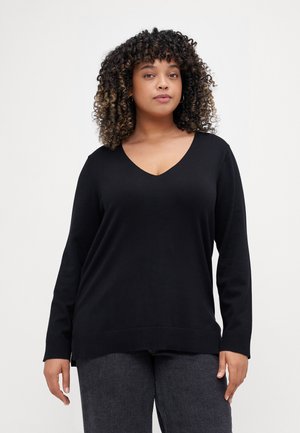 Black long-sleeve V-neck sweater made of soft fabric, featuring ribbed cuffs and hem, slightly oversized fit, paired with dark grey jeans.