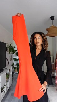 Orange fitted dress with a flared hem, made of smooth fabric. Long length with no visible patterns or embellishments.