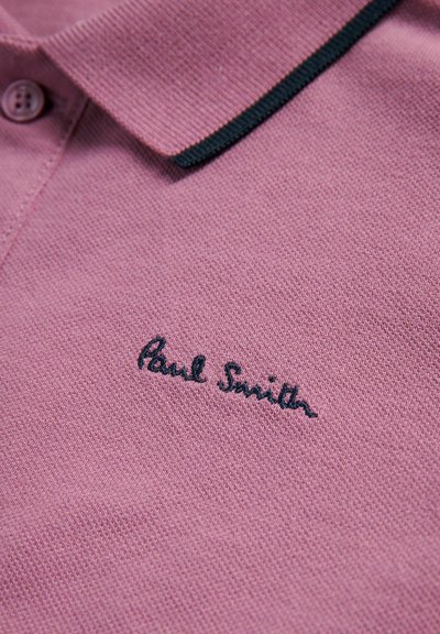 Lyserød polo-shirt i en tekstureret stof, med krave der har sort kant og den broderede 'Paul Smith' logo i mørk tråd.