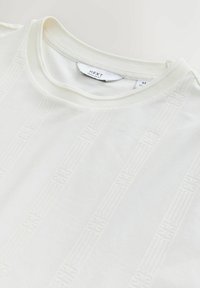 T-shirt bianca con collo rotondo, righe verticali sottili e testurizzate e etichetta "NEXT Regular Fit" all'interno del collo.