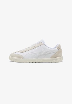 Sneaker bianca a profilo basso con dettagli in suede beige, chiusura con lacci e suola leggermente texturizzata, vista dal lato esterno.