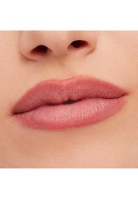 Nærbilde av myke, fyldige lepper i en dempet rosa tone, med en jevn tekstur og subtil glans, som fremhever naturlige konturer og fylde.