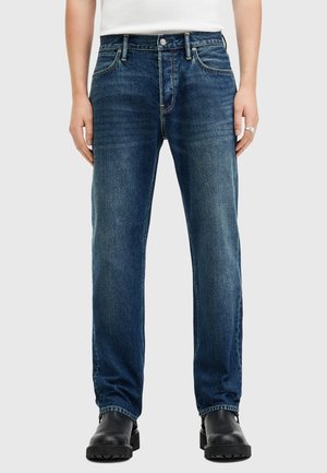 Dark blue denim jeans with a straight cut, five pockets, light fading, and a zipper fly. Features metal button and stitching accents.