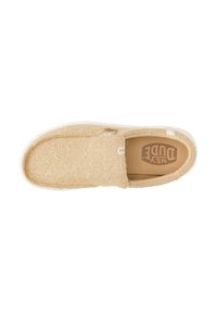 Zapato beige sin cordones con parte superior de tela texturizada, suela de goma blanca y discreto detalle del logo en la plantilla. Diseño de punta redondeada.