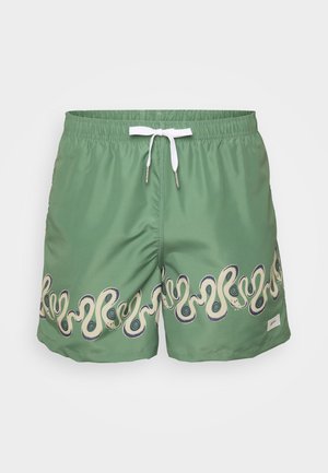 Grønne svømmebukser laget av polyester med en hvit snor. Har et bølgemønster i kremfarge og marineblå langs kanten.