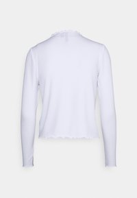 Vit långärmad topp med ribbat mönster, scalloped halsringning och ojämn fåll. Tyget verkar vara lätt och kroppsnära.