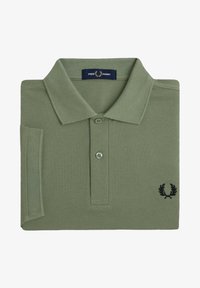 Polo shirt verde oliva in tessuto testurizzato, con pattina a due bottoni e logo ricamato in nero sul petto sinistro.