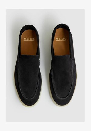 Černé semišové loafery s hladkým povrchem, širokým otvorem a mírně zvýšenou gumovou podrážkou. Branding viditelný na stélce.