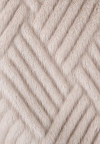 Gestructureerde stof in lichtbeige met een verhoogd visgraatpatroon; zachte, pluizige oppervlakte benadrukt door verschillende draadhoogtes.