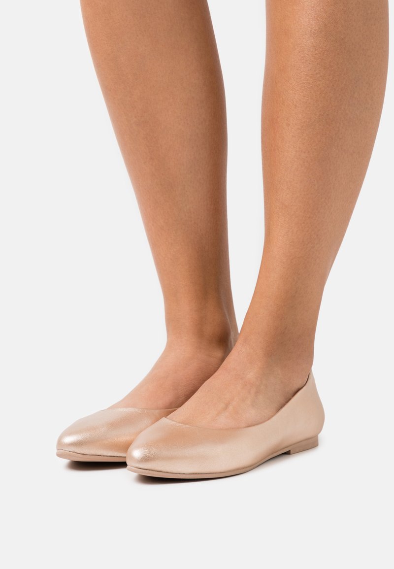 Ballerines nudes en cuir lisse, à bout arrondi, au design minimaliste et à semelle basse et plate.