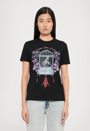Black cotton t-shirt featuring a colorful graphic design of a birdcage with flowers and tassels. Crew neck and short sleeves.